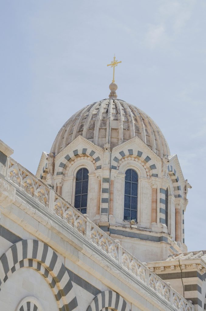 Low angle shot of Marseille Cathedral's dome, highlighting its intricate architecture against a clear sky.